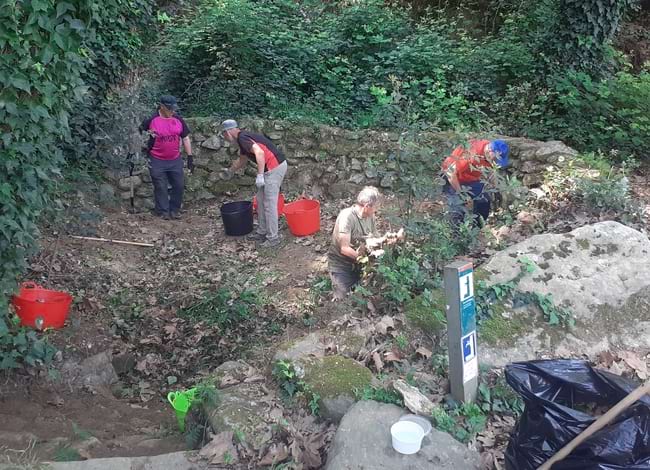 Grup de voluntaris d'Agrupe netejant de sorra i runes la font. Autor: Ricard Cases / Agrupe