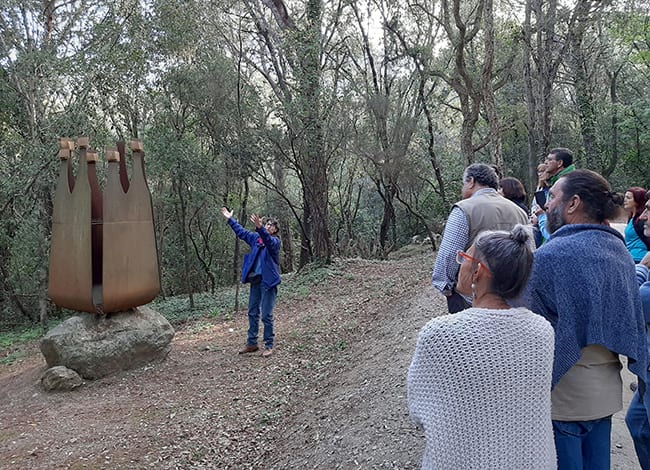 La guia mostrant una escultura de la catedral del bosc. Autor: Escola de Natura del Corredor