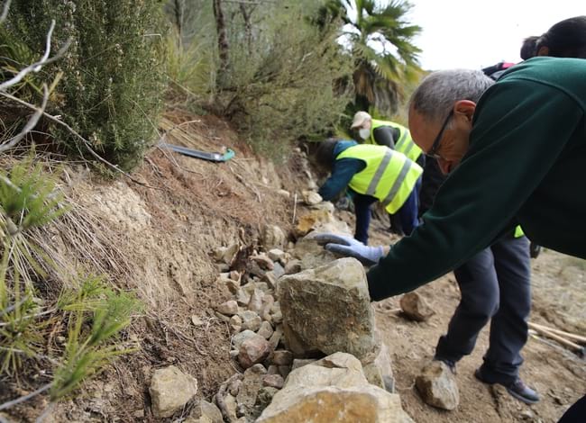 Grup de voluntaris durant la reconstrucció d'un mur de pedra seca a l'entorn de Can Grau. Autor: Cercle de Voluntaris