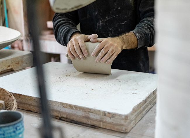 Madrenas durant la realització d'una de les peces de ceràmica al seu taller. Autoria: Parc del Castell de Montesquiu